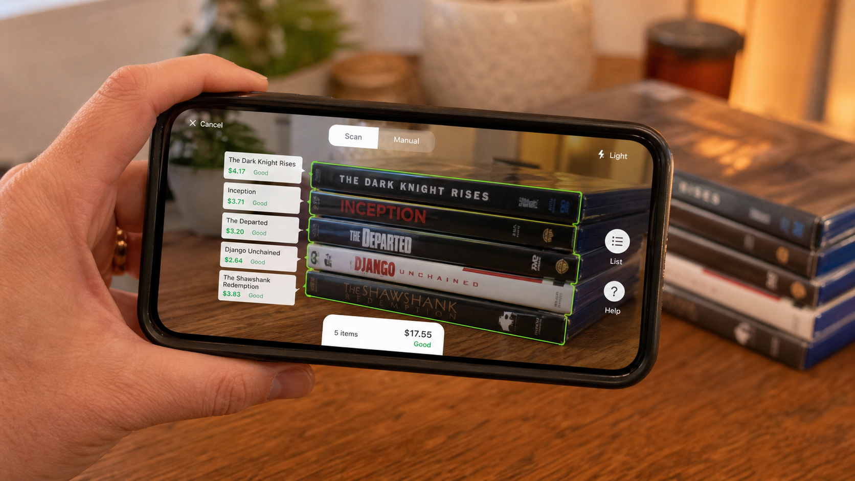 A cell phone scanning a stack of DVDs and displaying live price details on screen